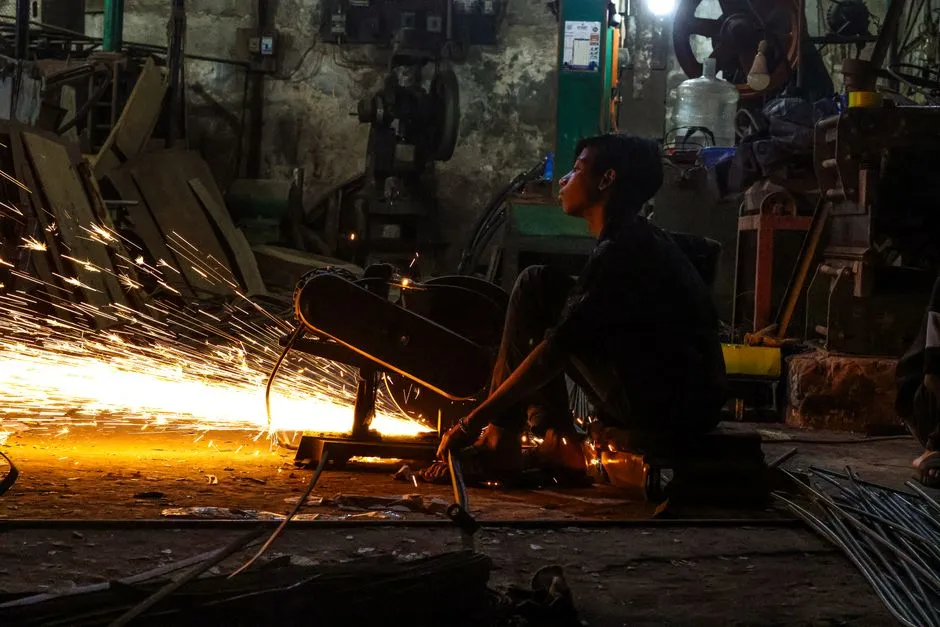 Silhouette of a worker in an industrial workshop, representing round-the-clock shift work